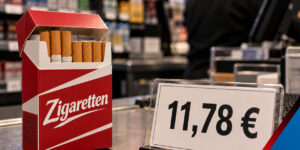 Rote Zigarettenschachtel mit der Aufschrift „Zigaretten“ neben einem Preisschild mit 11,78 Euro an einer Ladenkasse.